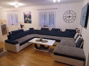 a living room with a blue couch and a table at Apartmani Marijamagdalena in Gračac
