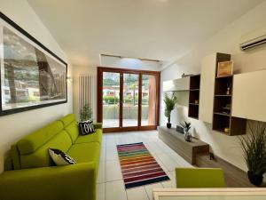 ナーゴ・トルボレにあるOutdooredo Garda Torboleのリビングルーム(緑のソファ、窓付)