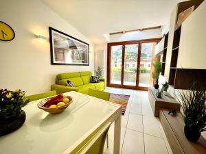 una sala de estar con sofá y un bol de fruta en una mesa en Outdooredo Garda Torbole, en Nago-Torbole