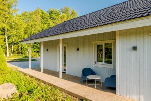 Casa con porche de madera con mesa y sillas en Haagi-Villa en Herjava
