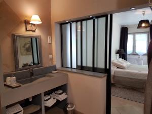 a bathroom with a sink and a bed and a mirror at Le jardin de Saint Jean in Saint-Jean-aux-Bois +66 photos