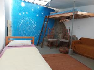 1 dormitorio con litera y pared azul en Twin room in the greenhouse close to mountains and surf paradise en Tejina