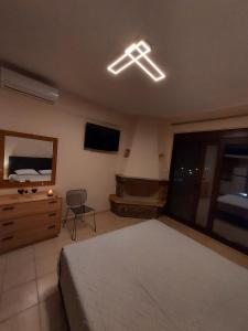 a bedroom with a bed and a tv and a couch at Prego Living Apartments in Vathí