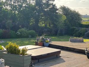 a wooden deck with potted plants and a garden at Escape to A Luxury Country Home 