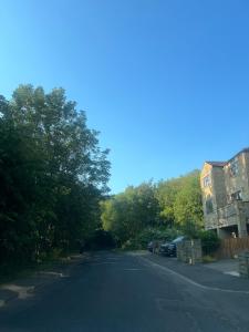 an empty street with trees on the side of the road at House of Kaima - 6 bed detached in Dewsbury