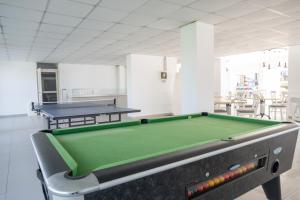 a pool table in a room with two tables at Napa Jay Hotel in Ayia Napa