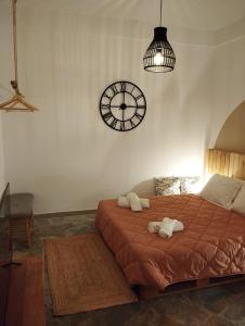 sypialnia z łóżkiem i zegarem na ścianie w obiekcie Wilson & Andrew House - Boho Bliss w mieście (( Sgoúrna ))
