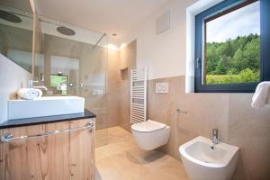 een badkamer met een wastafel en een toilet en een raam bij Apartments LaBar in Ortisei +33 foto's