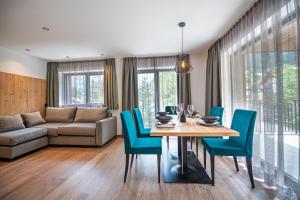 een woonkamer met een tafel, stoelen en een bank bij Apartments LaBar in Ortisei