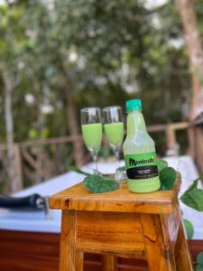 una botella de zumo verde y dos vasos en una mesa en Villa Feliz Ecolodge, en Monterrey
