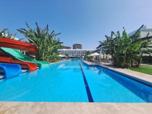 a pool at the resort with a water slide at Courtyard Long Beach Apartment in Iskele