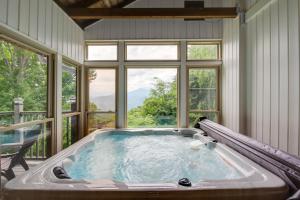 a jacuzzi tub in a room with windows at Gatlinburg Home Mountain Views and Indoor Hot Tub! in Gatlinburg
