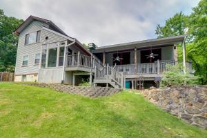 a large house with a porch and a stone wall at Gatlinburg Home Mountain Views and Indoor Hot Tub! in Gatlinburg
