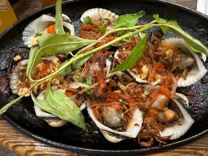 un plato negro de comida con setas y verduras en Room in Vietnam 1 en Ben Tre