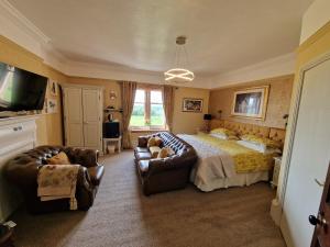 a bedroom with a bed and couches and a television at Hay Farm House in Ford
