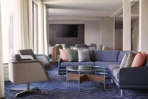 a living room with a blue couch and chairs at Courtyard by Marriott St. Louis Downtown West in Saint Louis