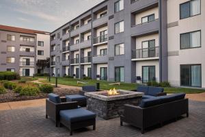 une cour avec des chaises et un foyer extérieur en face d'un bâtiment dans l'établissement Courtyard by Marriott St. Louis Downtown West, à Saint-Louis