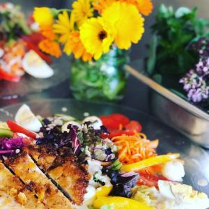 une assiette de nourriture sur une table avec des fleurs dans l'établissement Adam & Eva Gasthof Paradies mit Hotel, à Vogt