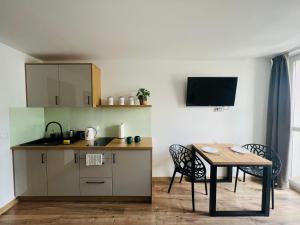 a small kitchen with a table and a table and chairs at Mare e Monti Apartments in Katowice