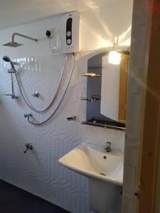 Baño blanco con lavabo y espejo en Dream Forest Rest en Ahangama