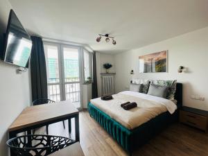 Schlafzimmer mit einem Bett, einem TV und einem Tisch in der Unterkunft Mare e Monti Apartments in Kattowitz