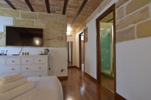 ein Schlafzimmer mit einem weißen Bett und einer Steinmauer in der Unterkunft BIBI'S HOUSE in Terrasini