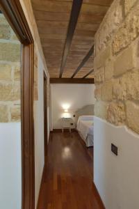 ein Schlafzimmer mit einem Bett und einer Steinmauer in der Unterkunft BIBI'S HOUSE in Terrasini