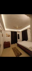 a bedroom with a bed and a couch and a ceiling at Panah . in Guwahati