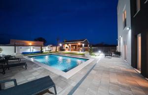 a swimming pool in the middle of a patio at night at D-Palace-Adriatic in Donji Zemunik