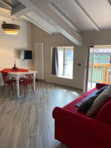 uma sala de estar com um sofá vermelho e uma mesa em Ca' Giorgina Apartments 2 em Arco