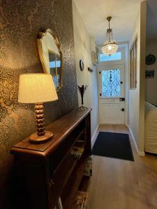een lamp op een tafel in een kamer met een spiegel bij Sisley Cottage in Moret-sur-Loing