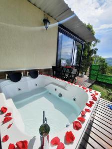 eine Whirlpool-Badewanne in einem Haus mit roten Rosen in der Unterkunft Cabañas Bellavista La Vega in La Vega