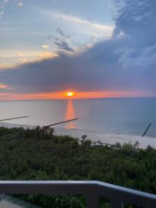 um pôr-do-sol sobre o oceano com o sol no horizonte em Porta Mare - Dziwnówek - Ferienappartment an der polnischen Ostsee em Dziwnówek