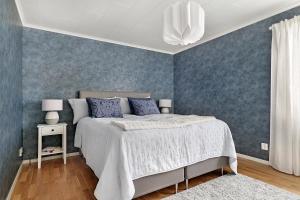 a bedroom with a bed and a blue wall at Guestly Homes - 3BR Business Getaway with Sauna in Boden