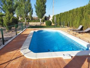 a swimming pool with a wooden deck and blue water at Casa rural cascales in Cervera del Llano