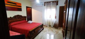 um quarto com uma cama vermelha e uma janela em B&B Calù em Cittadella del Capo