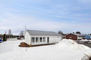 una casa blanca con nieve delante en Guestly Homes - 3BR Business Getaway with Sauna en Boden