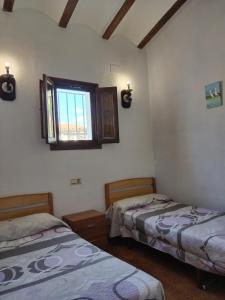 una habitación con dos camas y una ventana en Marítim family resort, Riumar, en Riumar
