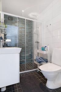 y baño blanco con aseo y ducha. en Guestly Homes - 3BR Business Getaway with Sauna en Boden