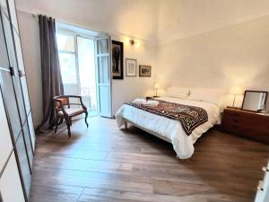 1 dormitorio con 1 cama, 1 silla y 1 ventana en Viaemilia Alessandria, en Alessandria