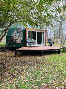 盧漢的住宿－Don Aniceto Lodges & Glamping，树下带两把椅子和一张桌子的帐篷