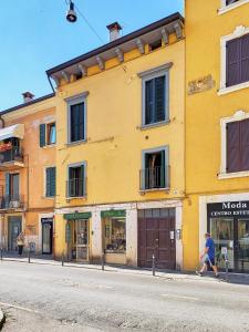 Um homem a andar numa rua em frente a um edifício amarelo em Casa San Paolo em Verona