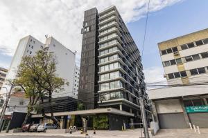 un edificio alto en una calle de la ciudad con edificios en Valpi GO 24 en Porto Alegre