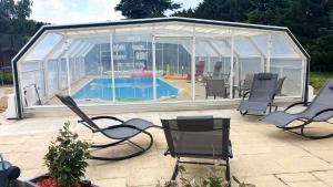 a greenhouse with chairs and a pool in it at Bois de Crâne in Landes-le-Gaulois