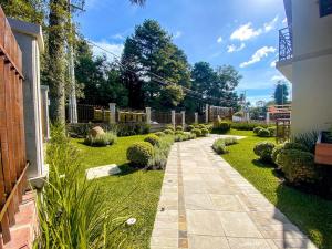 a garden with a walkway in a yard at Rosa Edifício Vivere Canela in Canela
