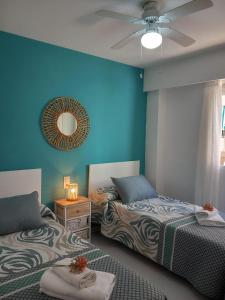 2 łóżka w pokoju z niebieską ścianą w obiekcie Caballito de mar, parking, AC y fibra VT-52619-V w mieście Gandía