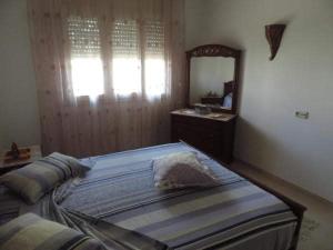 a bedroom with a bed with a dresser and a mirror at Appartement de charme in Nabeul