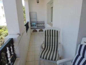 un porche con una silla a rayas y una ventana en Appartement de charme en Nabeul