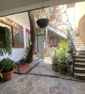un patio con un árbol y algunas plantas y escaleras en Appartamenti San Vito, en San Vito