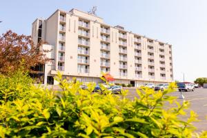 ein großes weißes Gebäude mit Autos auf einem Parkplatz in der Unterkunft Silver Beach Hotel in Saint Joseph